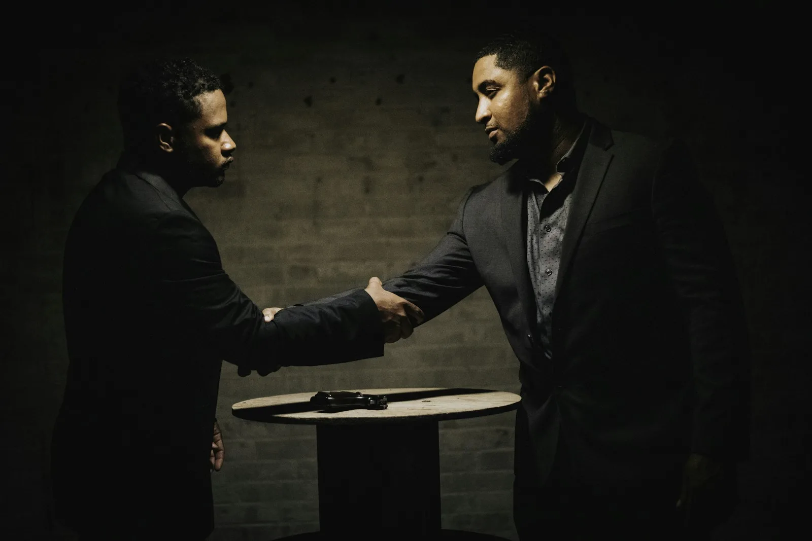 two men shaking hands in a dark room